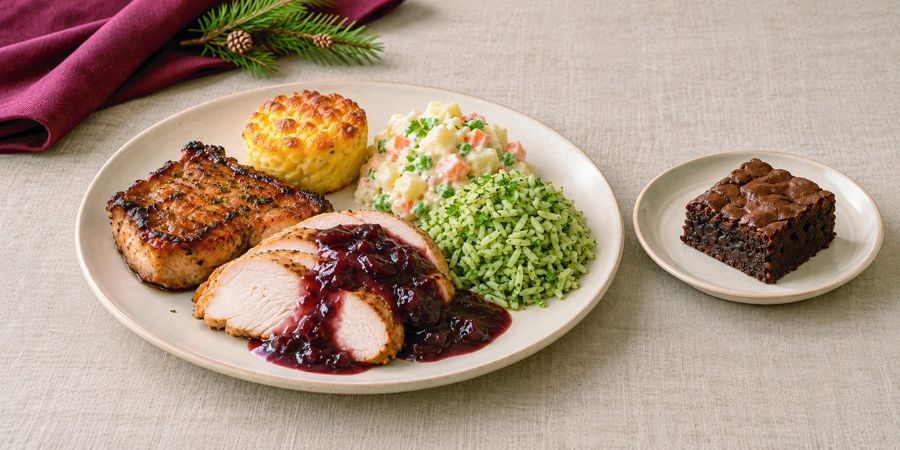 Medallón de pavo en salsa de ciruela, chuleta ahumada, soufflé de choclo, ensalada rusa, arroz verde y brownie